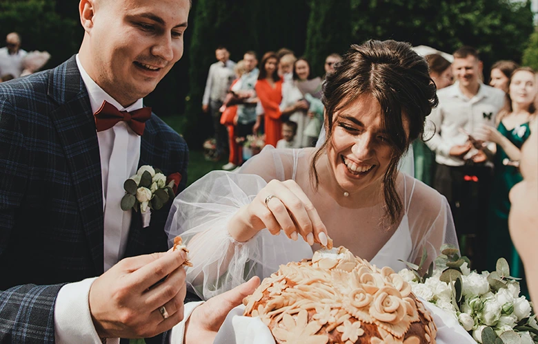A newly wed couple eating a bread as a tradition