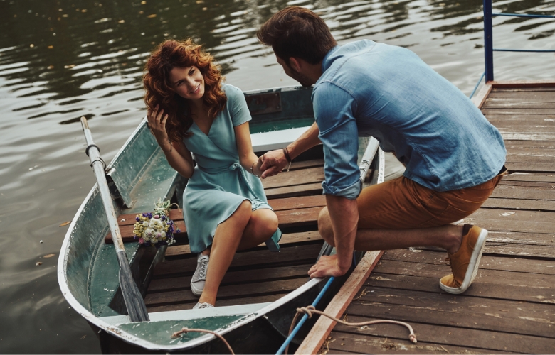 Happy couple ready to row a boat while enjoying their date outdoors